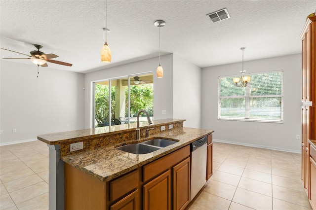 2827 Park Meadow Dr, Apopka, FL 32703 - kitchen with dishwasher, light tile patterned floors, a center island with sink, brown cabinetry, and pendant lighting