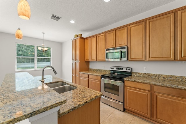 2827 Park Meadow Dr, Apopka, FL 32703 - kitchen featuring stainless steel appliances, recessed lighting, light stone counters, brown cabinetry, and a center island with sink