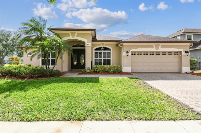 14003 Sobrado Dr, Orlando, FL 32837 - mediterranean / spanish-style house featuring a garage, decorative driveway, stucco siding, and a front yard