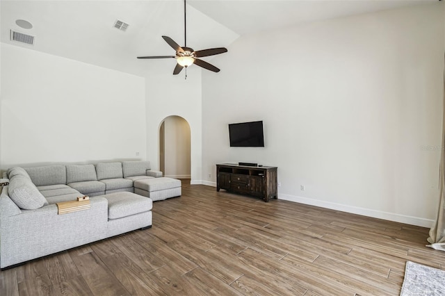 14003 Sobrado Dr, Orlando, FL 32837 - unfurnished living room with arched walkways, ceiling fan, wood finished floors, baseboards, and high vaulted ceiling