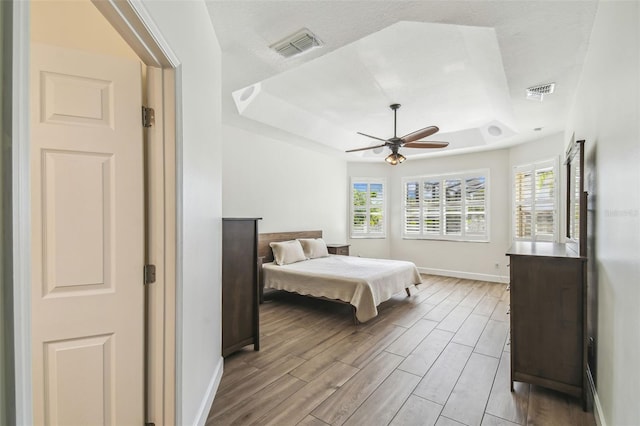 14003 Sobrado Dr, Orlando, FL 32837 - bedroom with a tray ceiling, baseboards, light wood-style flooring, and a ceiling fan