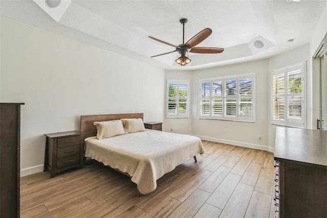 14003 Sobrado Dr, Orlando, FL 32837 - bedroom with multiple windows, baseboards, light wood finished floors, and a raised ceiling