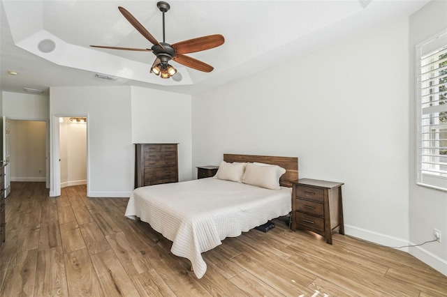 14003 Sobrado Dr, Orlando, FL 32837 - bedroom featuring a raised ceiling, light wood finished floors, and multiple windows