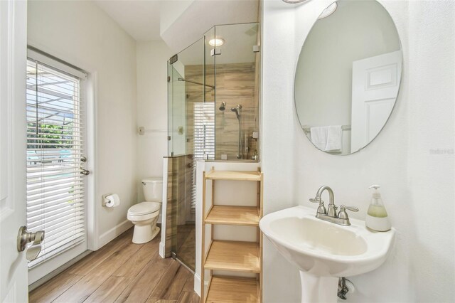 14003 Sobrado Dr, Orlando, FL 32837 - full bathroom featuring a stall shower, toilet, a sink, baseboards, and wood finished floors
