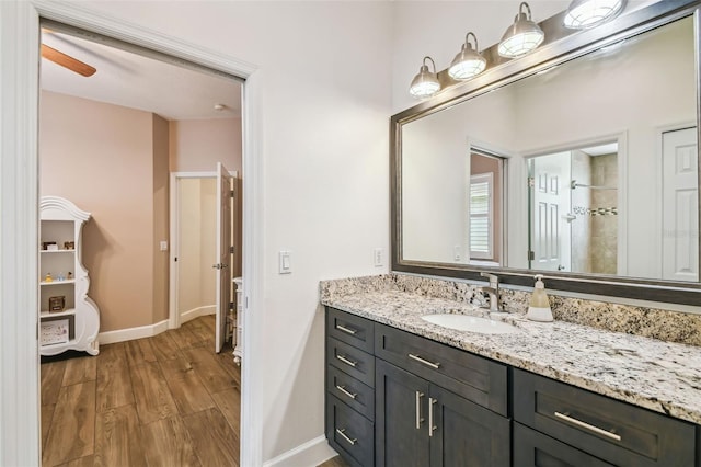 14003 Sobrado Dr, Orlando, FL 32837 - bathroom featuring wood finished floors, vanity, baseboards, and tiled shower