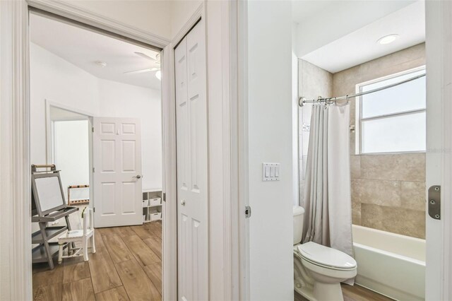 14003 Sobrado Dr, Orlando, FL 32837 - bathroom with wood finished floors, toilet, a ceiling fan, and shower / bath combination with curtain