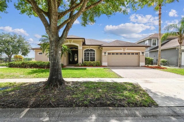 14003 Sobrado Dr, Orlando, FL 32837 - view of front of home with stucco siding, a garage, driveway, and a front lawn