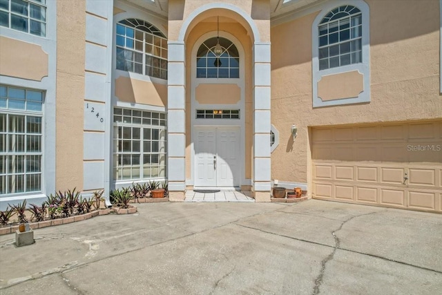 1240 Falconcrest Blvd, Apopka, FL 32712 - entrance to property with stucco siding, an attached garage, and driveway