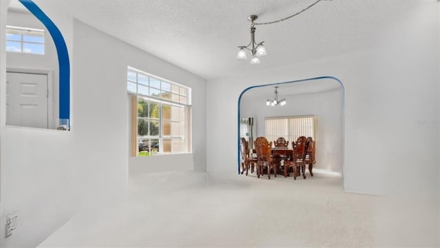 1240 Falconcrest Blvd, Apopka, FL 32712 - entrance foyer with a chandelier, plenty of natural light, a textured ceiling, and arched walkways