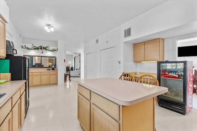 1240 Falconcrest Blvd, Apopka, FL 32712 - kitchen with light brown cabinetry, light countertops, and a center island