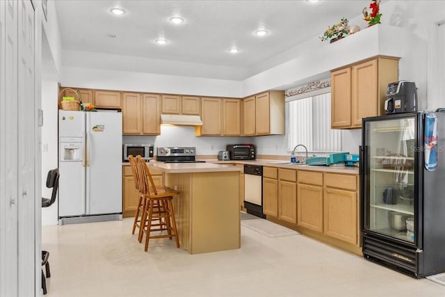 1240 Falconcrest Blvd, Apopka, FL 32712 - kitchen with appliances with stainless steel finishes, under cabinet range hood, a center island, a kitchen bar, and light countertops