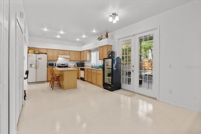 1240 Falconcrest Blvd, Apopka, FL 32712 - kitchen featuring appliances with stainless steel finishes, french doors, light countertops, a breakfast bar area, and under cabinet range hood