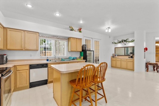 1240 Falconcrest Blvd, Apopka, FL 32712 - kitchen featuring dishwasher, light brown cabinets, electric range, light countertops, and recessed lighting