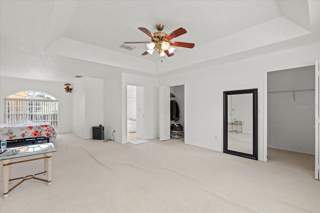 1240 Falconcrest Blvd, Apopka, FL 32712 - carpeted bedroom with a tray ceiling, a walk in closet, connected bathroom, and a ceiling fan