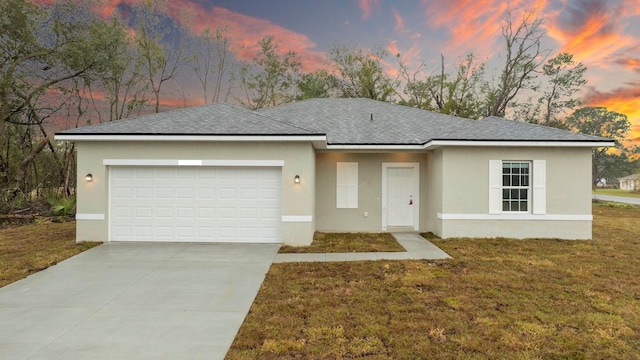 single story home with stucco siding, an attached garage, a shingled roof, and a front lawn