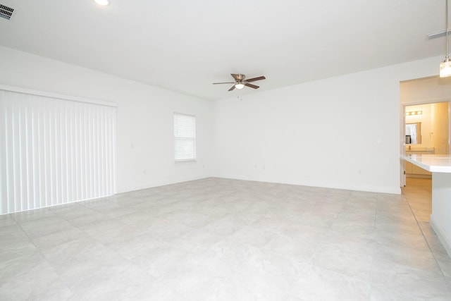unfurnished room with visible vents, baseboards, and a ceiling fan