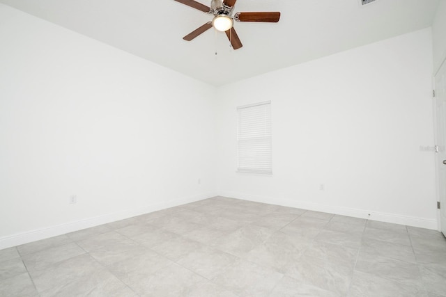spare room featuring ceiling fan and baseboards
