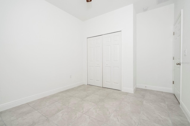 unfurnished bedroom featuring a closet, baseboards, and a ceiling fan