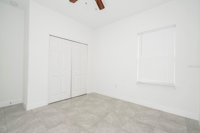 unfurnished bedroom featuring a closet, baseboards, and ceiling fan