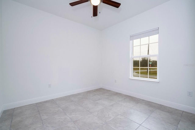 unfurnished room featuring ceiling fan and baseboards