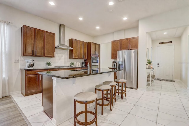 17084 Harbor Oak Pkwy, Winter Garden, FL 34787 - kitchen with wall chimney range hood, stainless steel fridge, a breakfast bar, light marble finish floors, and an island with sink