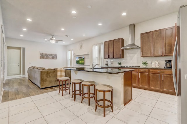 17084 Harbor Oak Pkwy, Winter Garden, FL 34787 - kitchen with wall chimney range hood, a kitchen breakfast bar, open floor plan, recessed lighting, and stainless steel gas cooktop