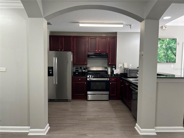 14501 Grove Resort Unit 1409, Winter Garden, FL 34787 - kitchen featuring appliances with stainless steel finishes, dark brown cabinets, exhaust hood, dark countertops, and arched walkways