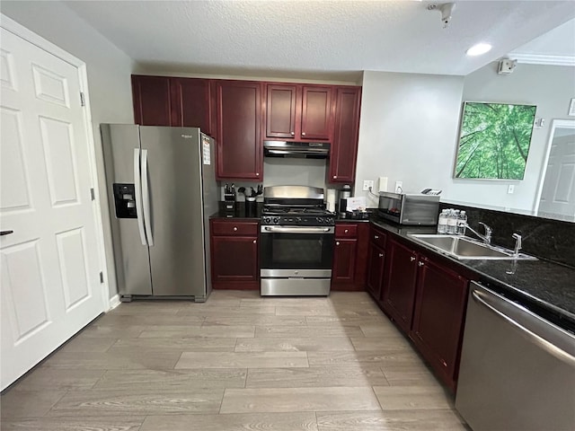 14501 Grove Resort Unit 1409, Winter Garden, FL 34787 - kitchen with appliances with stainless steel finishes, dark brown cabinets, a sink, dark countertops, and under cabinet range hood