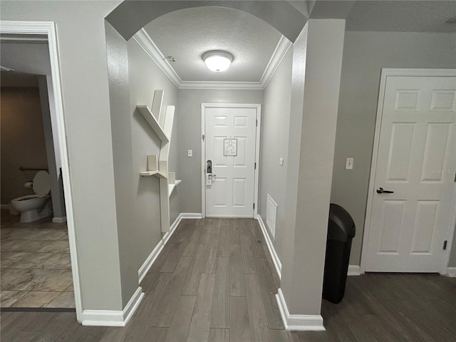 14501 Grove Resort Unit 1409, Winter Garden, FL 34787 - entryway featuring arched walkways, ornamental molding, wood finished floors, baseboards, and a textured ceiling