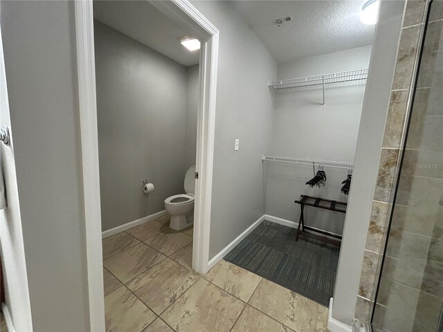 14501 Grove Resort Unit 1409, Winter Garden, FL 34787 - full bath with a spacious closet, toilet, baseboards, and a textured ceiling