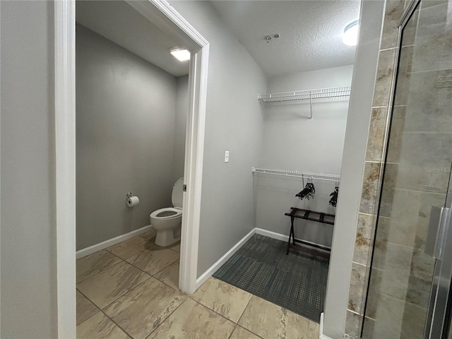 14501 Grove Resort Unit 1409, Winter Garden, FL 34787 - full bath with toilet, a walk in closet, a textured ceiling, tiled shower, and baseboards