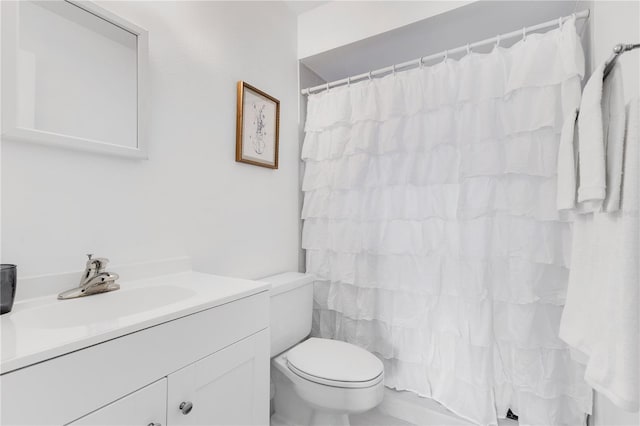 bathroom with toilet, vanity, and a shower with shower curtain