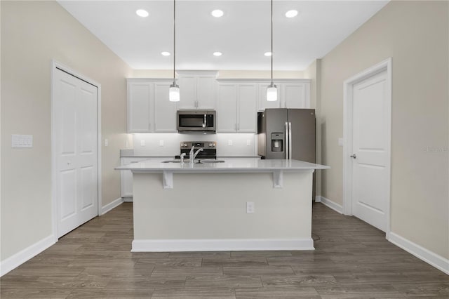 15060 Book Club Rd, Winter Garden, FL 34787 - kitchen featuring stainless steel appliances, white cabinets, light countertops, a center island with sink, and dark wood finished floors
