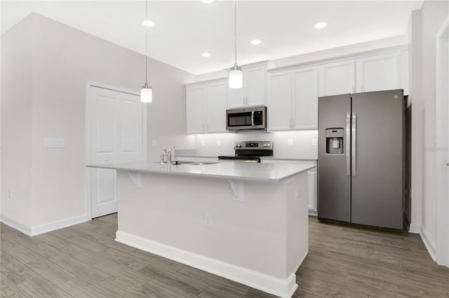 15060 Book Club Rd, Winter Garden, FL 34787 - kitchen with stainless steel appliances, wood finished floors, a center island with sink, light countertops, and recessed lighting