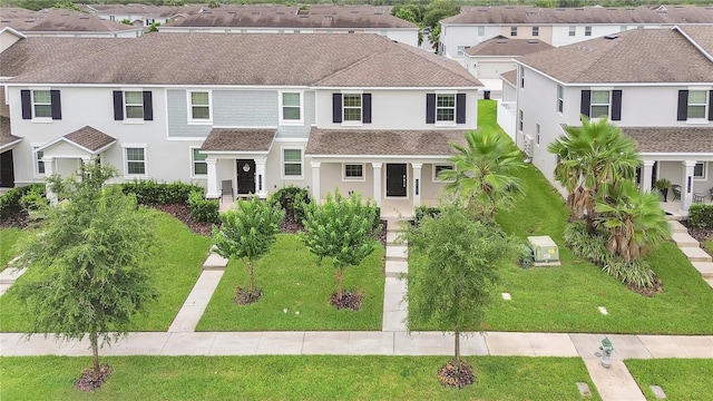 15060 Book Club Rd, Winter Garden, FL 34787 - townhome / multi-family property with stucco siding, a shingled roof, a residential view, a porch, and a front lawn