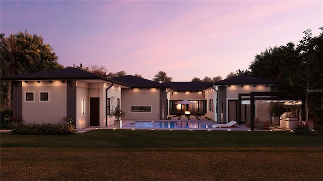 12818 Brunello Cir, Clermont, FL 34711 - back of house featuring a patio, a lawn, an outdoor pool, and stucco siding