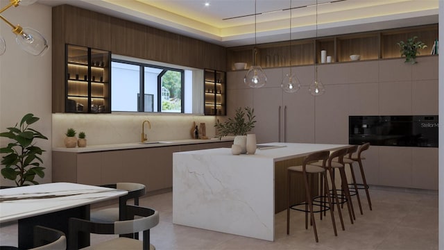 12818 Brunello Cir, Clermont, FL 34711 - kitchen with modern cabinets, light countertops, a kitchen island, a breakfast bar, and tasteful backsplash