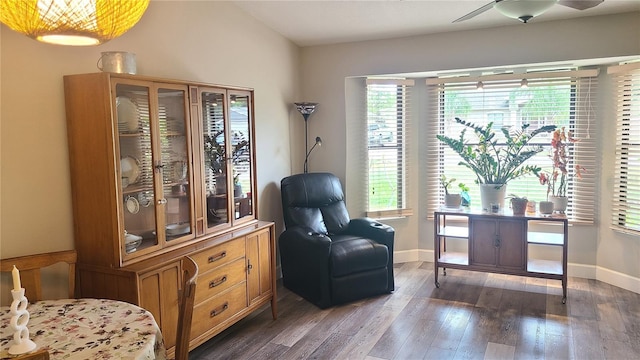 sitting room featuring dark wood-style flooring, a ceiling fan, and baseboards