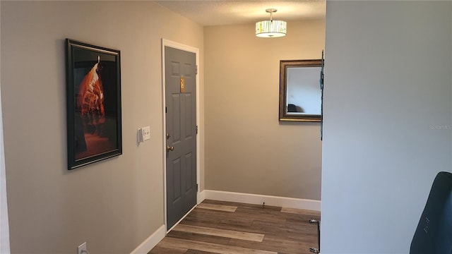 doorway to outside with dark wood-style floors and baseboards