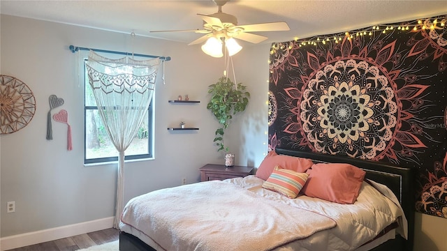 bedroom with wood finished floors, baseboards, and a ceiling fan