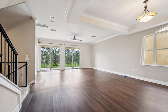 unfurnished living room featuring dark wood-style floors, a ceiling fan, ornamental molding, baseboards, and stairs