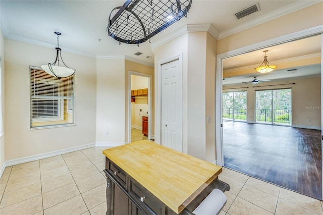 dining area featuring ceiling fan, light tile patterned floors, baseboards, and crown molding