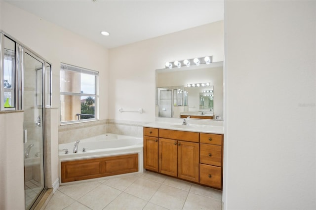 bathroom with tile patterned floors, a stall shower, a garden tub, and vanity