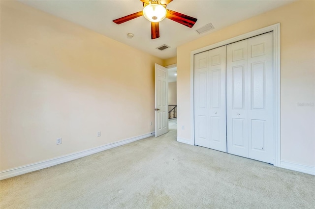 unfurnished bedroom featuring carpet, baseboards, a closet, and ceiling fan