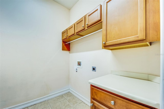 clothes washing area featuring electric dryer hookup, washer hookup, cabinet space, baseboards, and light tile patterned floors