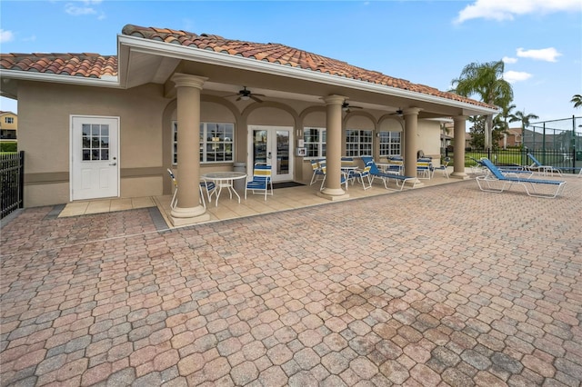 rear view of house featuring a ceiling fan, fence, french doors, and stucco siding