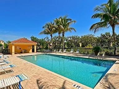 community pool featuring fence and a patio