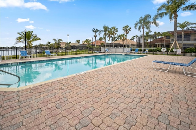 community pool with fence and a patio area