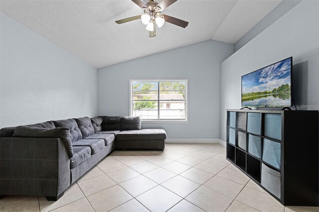 living room featuring ceiling fan, light tile patterned floors, lofted ceiling, and baseboards
