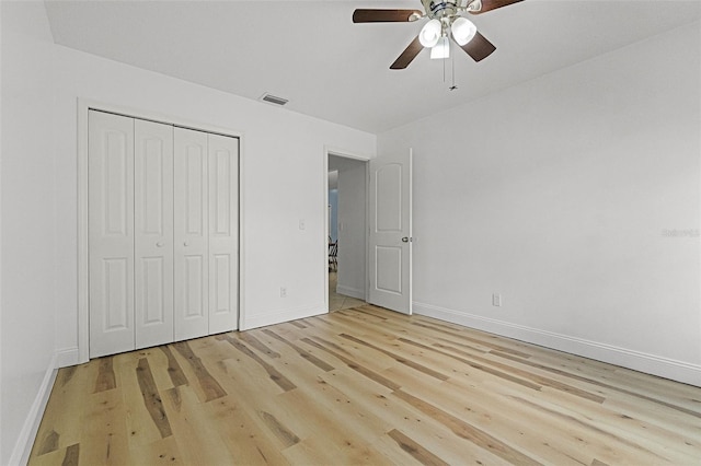 unfurnished bedroom featuring light wood-type flooring, baseboards, a closet, and ceiling fan